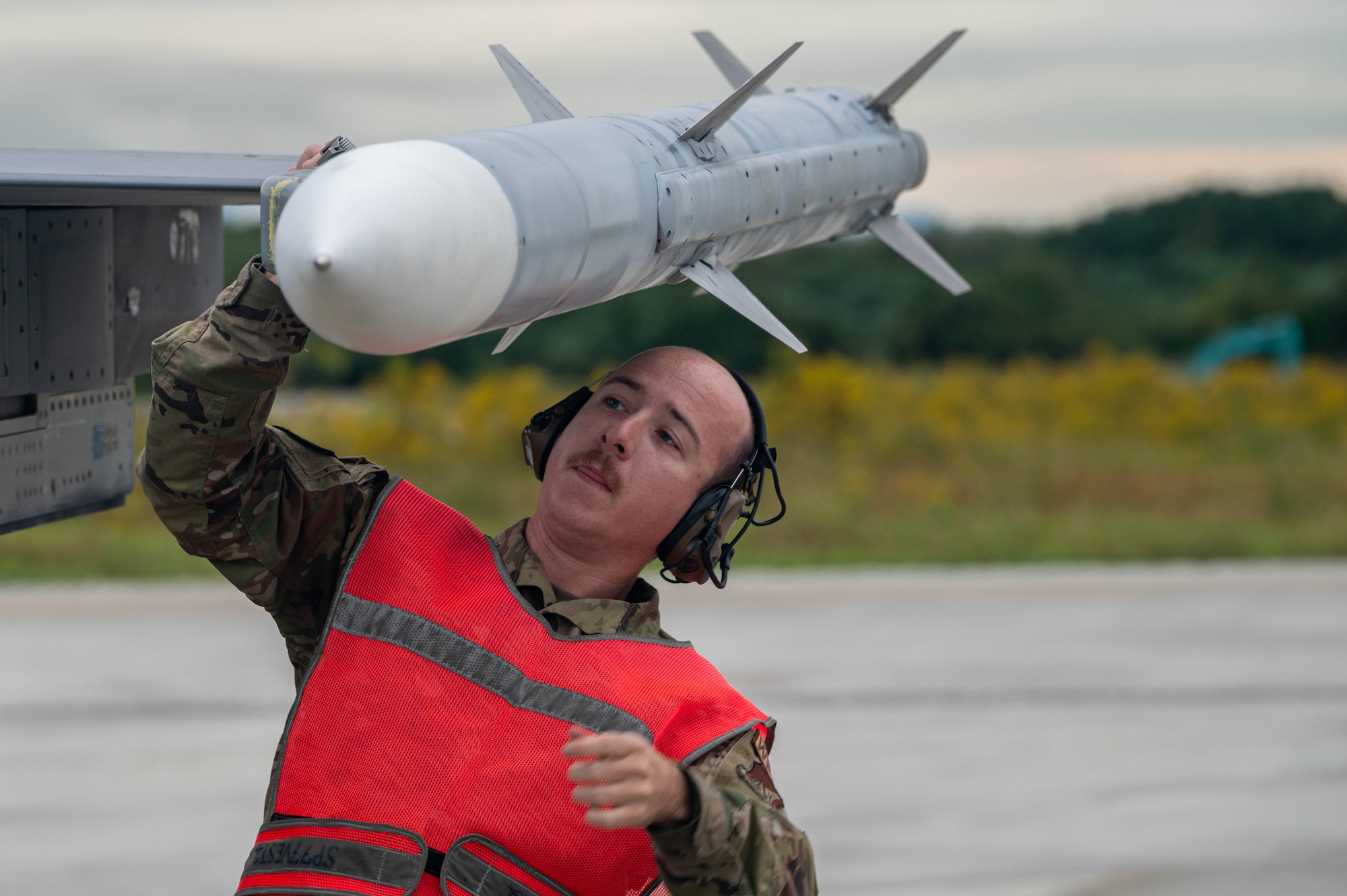 U.S. Air Force Senior Airman Wyatt Hicks, 77th Expeditionary Fighter Generation Squadron weapons load crew member, inspects the fins on a training AIM-120 advanced medium-range air-to-air missile during pre-flight inspections of an F-16 Fighting Falcon during Keen Sword 25 at Tsuiki Air Base, Japan, Oct. 28, 2024.
