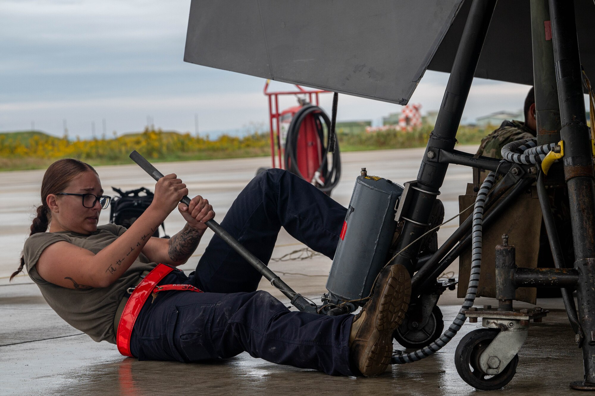 U.S. Air Force Airman Brianna Cloutier, 77th Expeditionary Fighter Generation Squadron crew chief, uses a jack to suspend an F-16 Fighting Falcon during Keen Sword 25 at Tsuiki Air Base, Japan, Oct. 28, 2024.