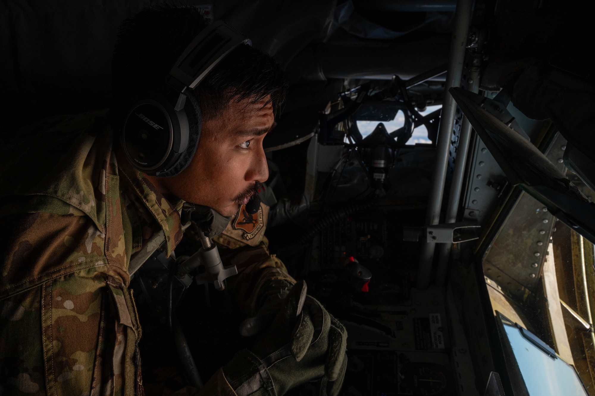 U.S. Air Force Staff Sgt. Zackery Yamagishi, 909th Air Refueling Squadron boom operator, waits in the boom pod of a KC-135 Stratotanker over the Japanese coastline, Nov. 8, 2024.