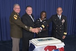 Four people cut cake during the Defense Logistics Energy 249th Navy birthday celebration.
