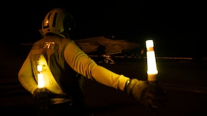 A U.S. Navy Boatswain's Mate (Handling) signals an F-35C Lightning II, attached to Marine Fighter Attack Squadron (VMFA) 314, as it prepares to launch from the flight deck of the Nimitz-class aircraft carrier USS Abraham Lincoln (CVN 72).