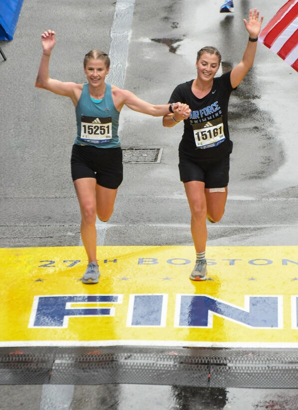 Air Force 1st Lt. Caroline Wittich, an intelligence officer, Patrick Air Force Base, Florida, and her sister, Maddie, cross the finish of the 27th Boston Marathon to honor the 10th anniversary of the 2013 bombing of the marathon April 17, 2023. Her father had been running the race while she and her family had been near the second bombing site. (Courtesy photo)