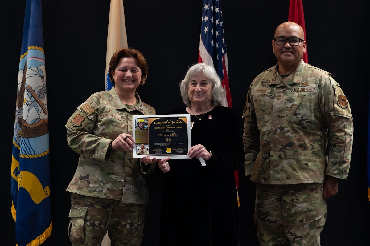U.S. Air Force Col. Angelina Maguinness, 17th Training Wing commander, and Chief Master Sgt. Jason Ramon, 17th Mission Support Group senior enlisted leader, pose for a photo with Pam Callan during the Honorary Commander Graduation and Induction ceremony at the Powell Event Center, Goodfellow Air Force Base, Texas, Nov. 7, 2024. Callan won the Distinguished Graduate award for the most participation in Honorary Commander events. (U.S. Air Force photo by Airman 1st Class Brian Lummus)