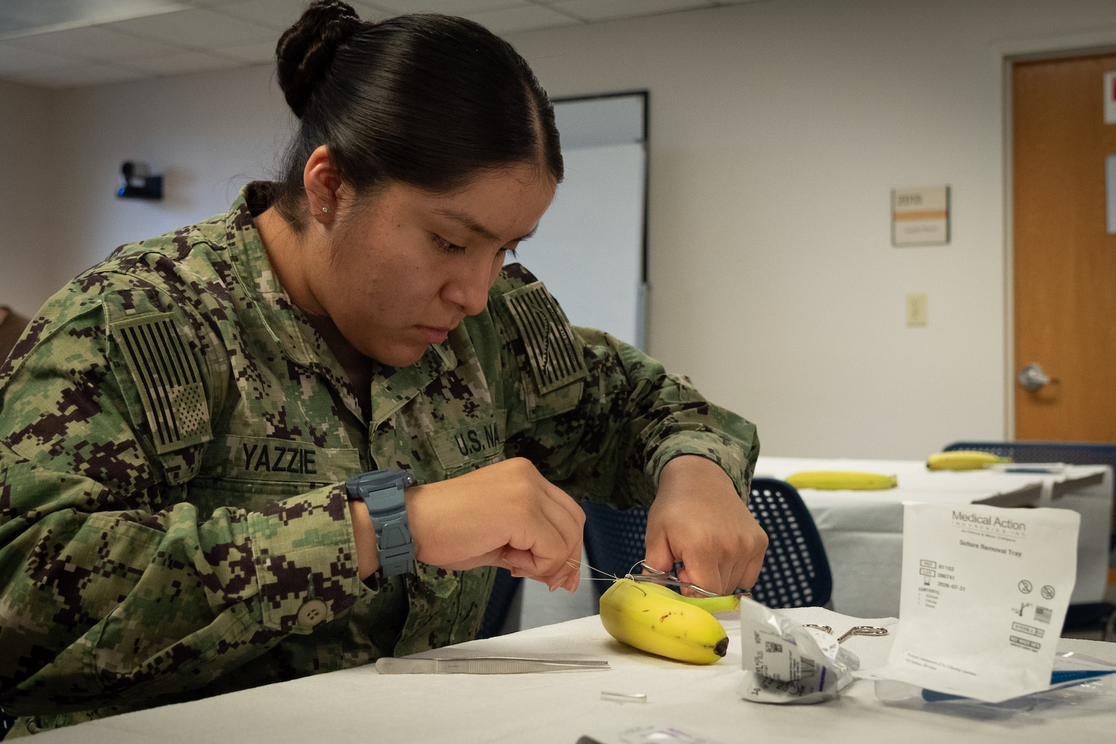 Hospitalman Cyerra Yazzie practices suturing techniques on a banana during a class held aboard Naval Health Clinic Cherry Point on Friday, November 15.  Bananas served as training aids for the class due to their thick and easy-to-pierce skin and the ability to distinguish the skin from the fruit.