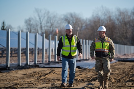 U.S. Air Force Capt. Dayton Brown (right), the base civil engineer, and Mr. Robert Letourneau, the base engineering technician, walk the grounds of the solar array expansion at the Vermont Air National Guard Base