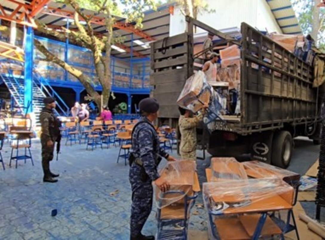 U.S. Army Captain Giovanni Valldejuli and Sgt. 1st Class Clayton Gransberg from the Civil Affairs team facilitate the pick up of a desk donation for schools throughout the Izabal region in Guatemala with three members of the Guatemalan Navy, Oct. 25, 2024. The Civil Affairs team serves as a liaison between the Guatemalan military, United States Agency for International Development, and the fabrication warehouse to ensure a seamless process from beginning to end for the betterment of our partner nations and their communities. (U.S. Army courtesy photo)