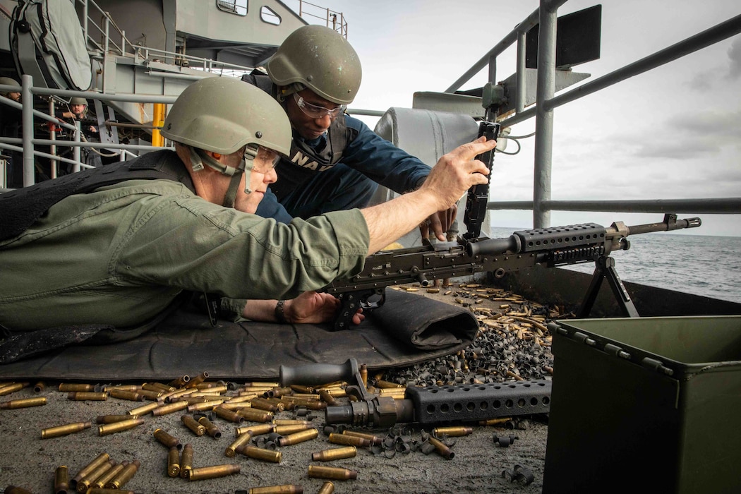 Capt. Robert Bibeau reloads an M240B machine gun aboard USS George H.W. Bush (CVN 77).