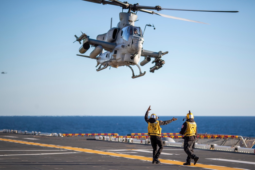 Sailors guide an AH-1Z Viper helicopter from HMLA-169 to land aboard USS Tripoli (LHA 7).