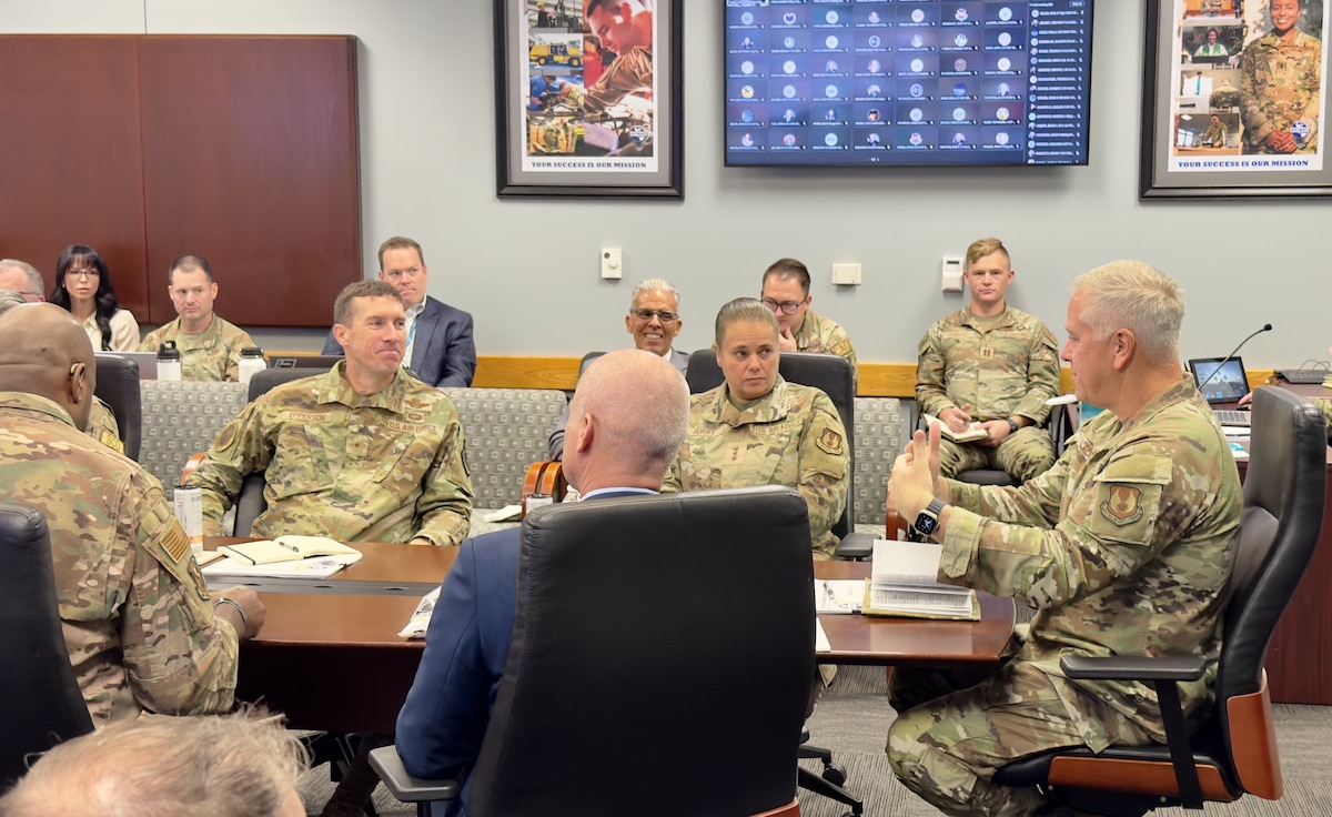 AFIMSC Airmen and Civilians sitting at a table participating in a discussion.