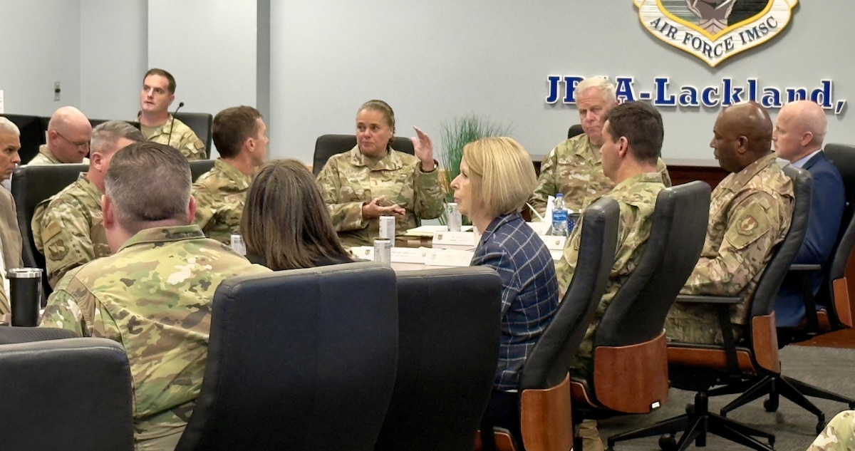 AFIMSC Airmen and civilians sitting at a table participating in a discussion.