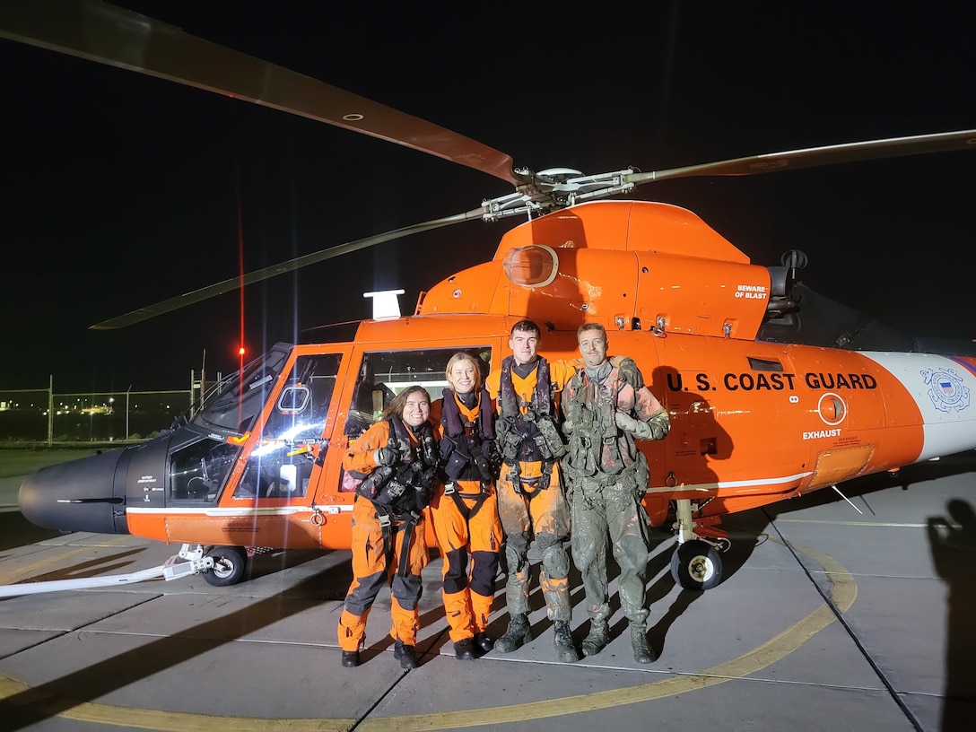 A Coast Guard Air Station San Francisco MH-65 Dolphin helicopter air crew poses for group photo at Air Station San Francisco after completing a search and rescue case on Nov. 15,2024. The aircrew rescued 3 individuals after their boat became grounded in San Pablo Bay, California. (U.S. Coast Guard photo)