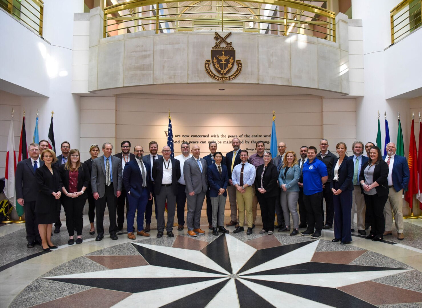 A group poses for a photograph in a large room.