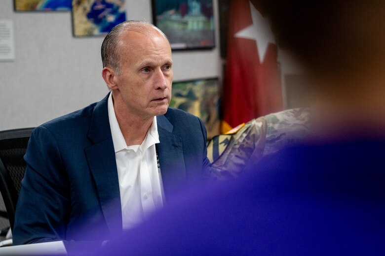 A man sits at a table during a meeting.