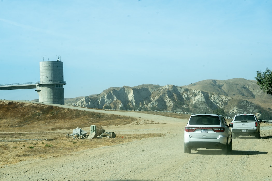 Two white vehicles approach Prado Dam