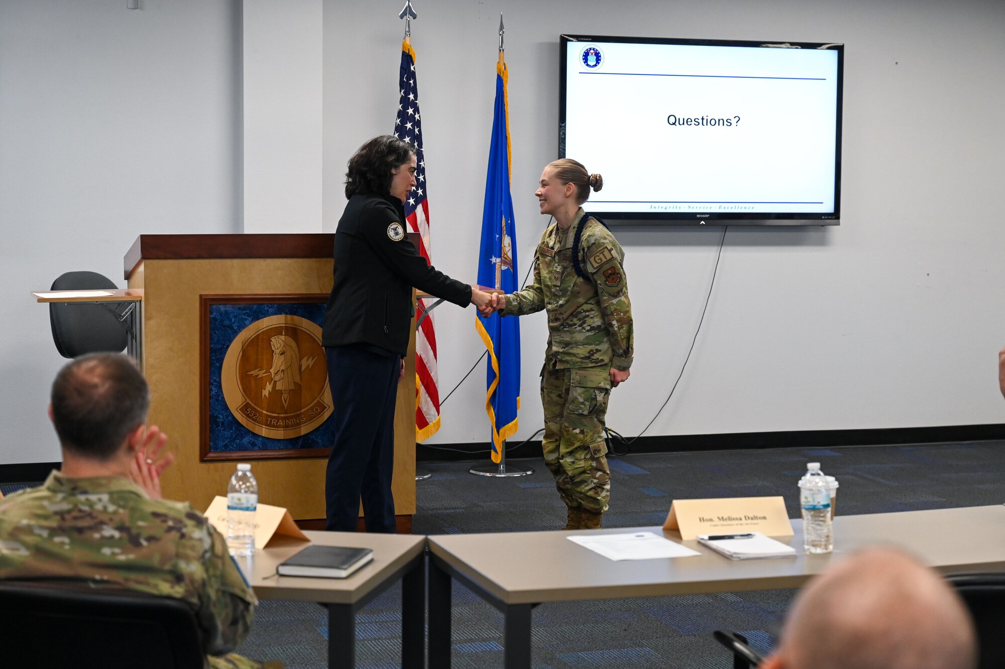 Dalton shakes hands with Barretto inside a conference room.