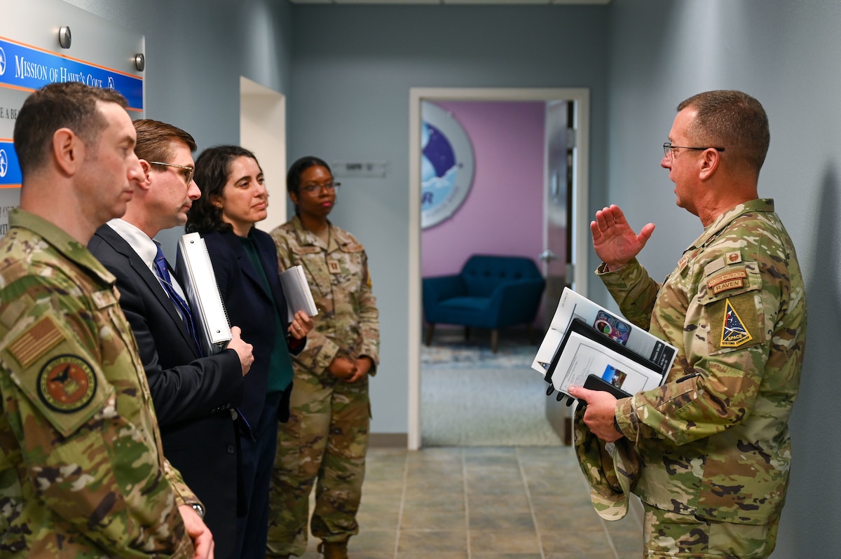 Jewell talks to a group in a hallway.