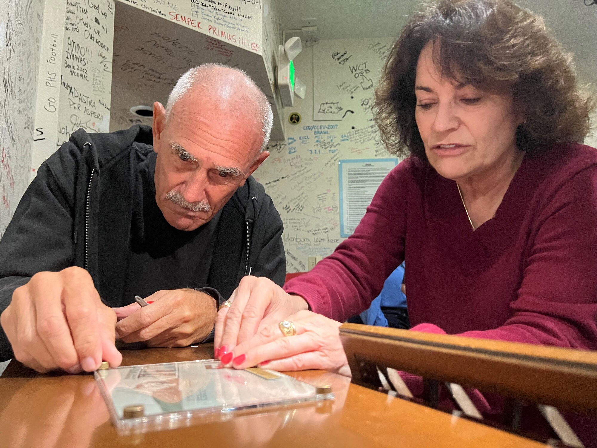 Ed and Heather Hayes tighten the plate screws around a photo of their mother.