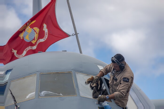 U.S. Marine Corps Master Gunnery Sgt. Christian Villalobos, a KC-130J Super Hercules flight engineer with Marine Aerial Refueler Transport Squadron (VMGR) 352, Marine Aircraft Group 11, 3rd Marine Aircraft Wing, cleans the exterior of a KC-130J during preflight checks at Guam International Airport, Sept. 7, 2024. VMGR-352 stopped in Guam while flying from Marine Corps Air Station Miramar, California to Camp Lemonnier, Djibouti, to deliver essential personnel, supplies and equipment to 3rd MAW squadrons deployed in support of Combined Joint Task Force-Horn Africa. (U.S. Marine Corps photo by Sgt. Emeline Swyers)