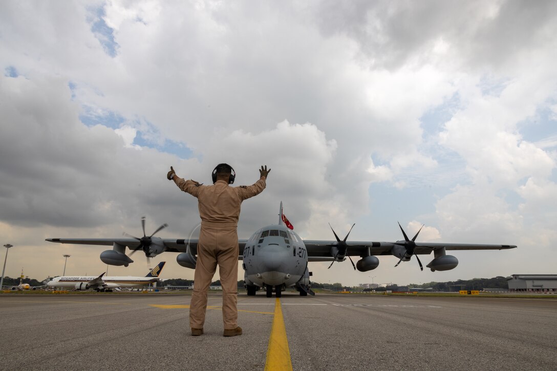 U.S. Marine Corps Master Gunnery Sgt. Christian Villalobos, a KC-130J Super Hercules flight engineer with Marine Aerial Refueler Transport Squadron (VMGR) 352, Marine Aircraft Group 11, 3rd Marine Aircraft Wing, communicates with pilots during engine startup prior to takeoff at Changi Airport, Singapore, Sept. 9, 2024. VMGR-352 stopped in Singapore while flying from Marine Corps Air Station Miramar, California to Camp Lemonnier, Djibouti, to deliver essential personnel, supplies and equipment to 3rd MAW squadrons deployed in support of Combined Joint Task Force-Horn Africa. (U.S. Marine Corps photo by Sgt. Emeline Swyers)
