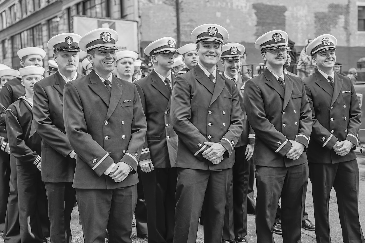 A group of sailors pose for a photo while in a New York City street.