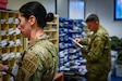 Pennsylvania Air National Guard Senior Airman Bella Badal, assigned to the 111th Operations Group and Staff Sgt. Michael Eagan, 111th Force Support Squadron, review and distribute mail in a mailroom on Ramstein Air Base Germany, Nov. 05, 2024. 111th ATKW airmen trained with mail team members at Ramstein AB to practice interoperability and Multi-capable airmen functioning in a deployed environment. (Pennsylvania Air National Guard photo by Senior Airman Charles Casner)