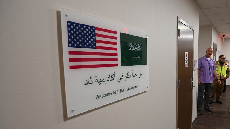 A plaque recognizing the Terminal High Altitude Area Defense Academy. The THAAD academy is a partnership between the Department of Defense and the Kingdom of Saudi Arabia to train Royal Saudi Air Defense Forces soldiers on how to implement the THAAD battery. In the background is Thomas Harraghy, chief of the Missile Defense Agency’s KSA THAAD Training Academy, left, and Andrew Davis, the project engineer for the renovation of the building from the U.S. Army Corps of Engineers, Fort Worth District’s Southwest Area Office.