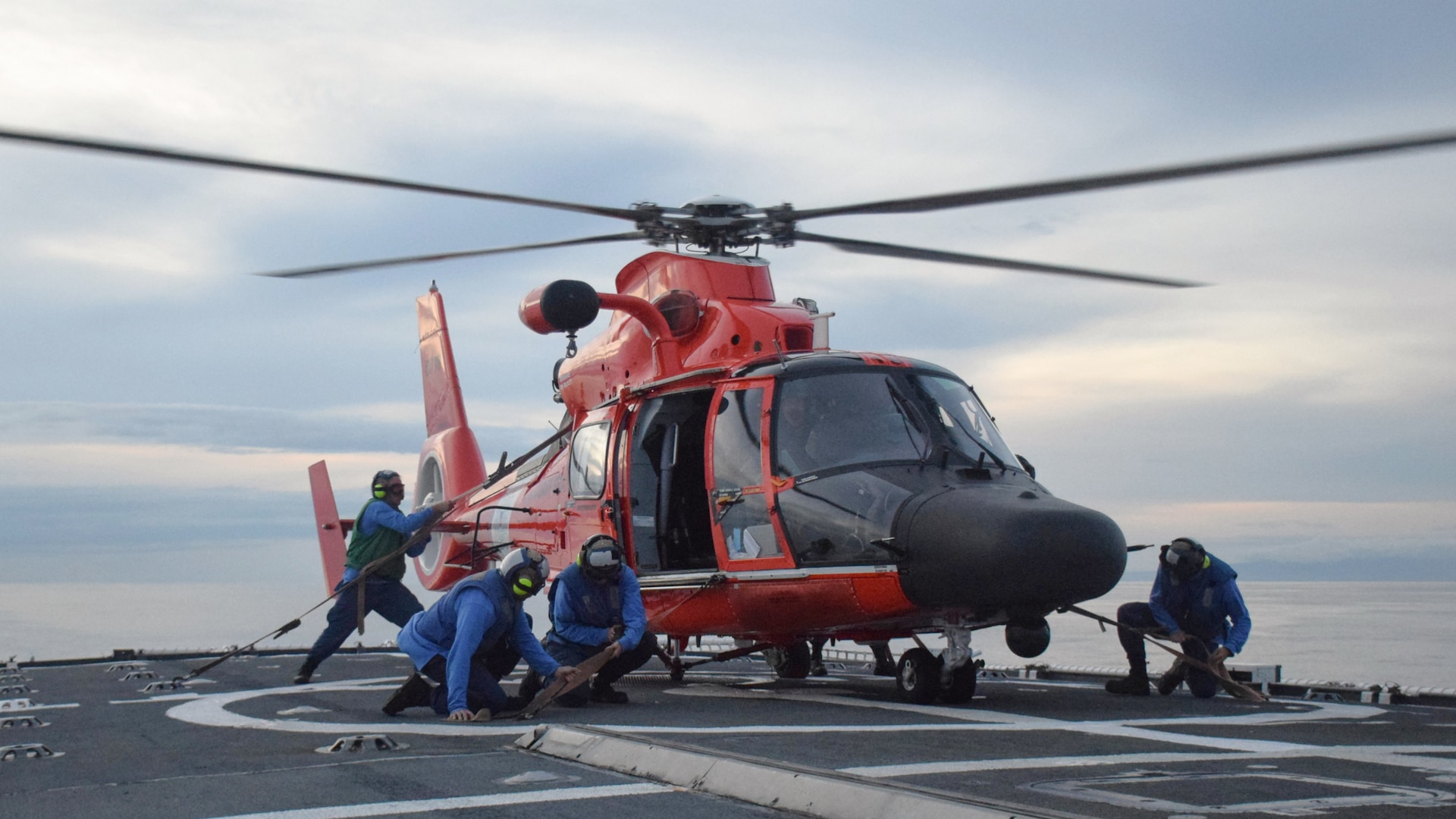 Coast Guard Cutter Seneca (WMEC 906) tiedown crew secures an embarked MH-65 Dolphin helicopter aircrew from the Coast Guard Helicopter Interdiction Tactical Squadron, Oct. 12, 2024, shortly after landing on the cutter’s flight deck at sea in the eastern Pacific Ocean. Seneca’s crew conducted a 61-day counter-drug patrol within the Coast Guard Eleventh District area of responsibility in support of Joint Interagency Task Force – South. (U.S. Coast Guard photo)