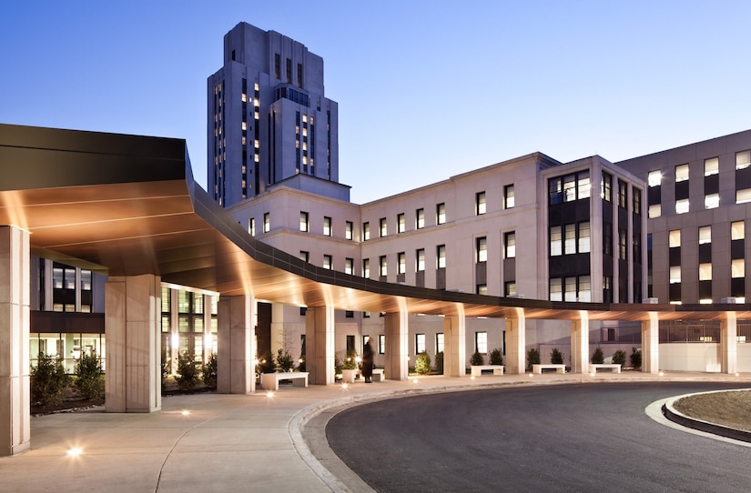 A large, lighted building is shown at sunrise.