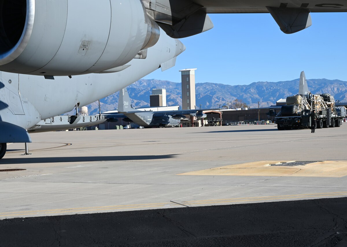 U.S. Air Force Airman 1st Class Emanuel Garcia, 355th Logistics Readiness Squadron air terminal function representative, delivers 49,500 pounds of cargo to a C-17 Globemaster III aircraft at Davis-Monthan Air Force Base, Arizona, Nov. 6, 2024. The 355th Logistics Readiness Squadron assisted the U.S. Army Test and Evaluation Command and U.S. Army Combat Capabilities Development Command Soldier Center (DEVCOM SC) with loading the heaviest fuel resupply load ever tested to enhance airdrop capabilities in support of a U.S. Transportation Command funded project. (U.S. Air Force photo by Staff Sgt. Abbey Rieves)