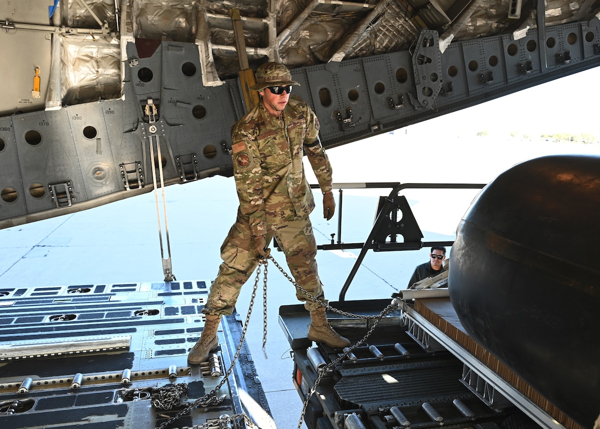 U.S. Air Force Staff Sgt. Harry Edmondson, 355th Logistics Readiness Squadron noncommissioned officer in charge of air transportation function operations, helps load 49,500 pounds of cargo at Davis-Monthan Air Force Base, Arizona, Nov. 6, 2024. Edmondson assisted US Army Combat Capabilities Development Command Soldier Center and U.S. Army Yuma Proving Ground with concept testing an airdrop by simulating an airdrop of over 37,000 pounds of aircraft fuel in an austere environment in support of a US Transportation Command funded project. (U.S. Air Force photo by Staff Sgt. Abbey Rieves)