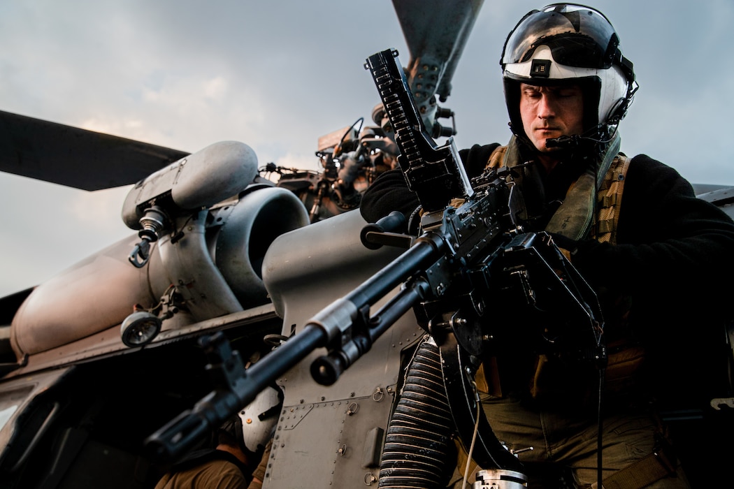 Naval Air Crewman (Helicopter) 3rd Class Jacob Gateman, from Vashon Island, Washington, assigned to the Golden Falcons of Helicopter Sea Combat Squadron (HSC) 12, inspects an M240D machine gun on an MH-60S Seahawk on the flight deck of Nimitz-class aircraft carrier USS George Washington (CVN 73), while underway in the Pacific Ocean, Nov. 13, 2024.