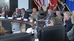 Men and women sit at a conference table.