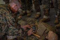 A U.S. Marine Corps recruit with Lima Company, 3rd Recruit Training Battalion, demonstrates the proper technique for applying a tourniquet during a tactical combat casualty care class for recruits with Lima Company, 3rd Recruit Training Battalion, at Marine Corps Recruit Depot San Diego, California, Nov. 5, 2024. TCCC is a three-phase approach to casualty management, ensuring the appropriate medical care is given at the correct time and place during any necessary scenario. (U.S. Marine Corps photo by Lance Cpl. Jacob B. Hutchinson)