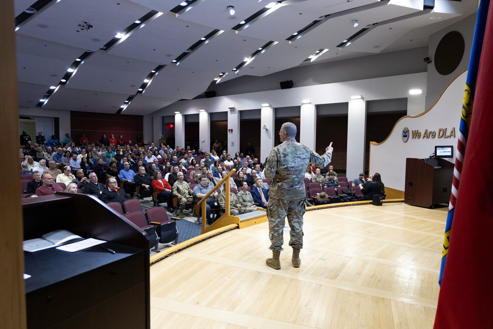 A light skinned man with graying hair in uniform speaks on stage.