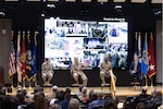 Four people sit on a stage answering questions.