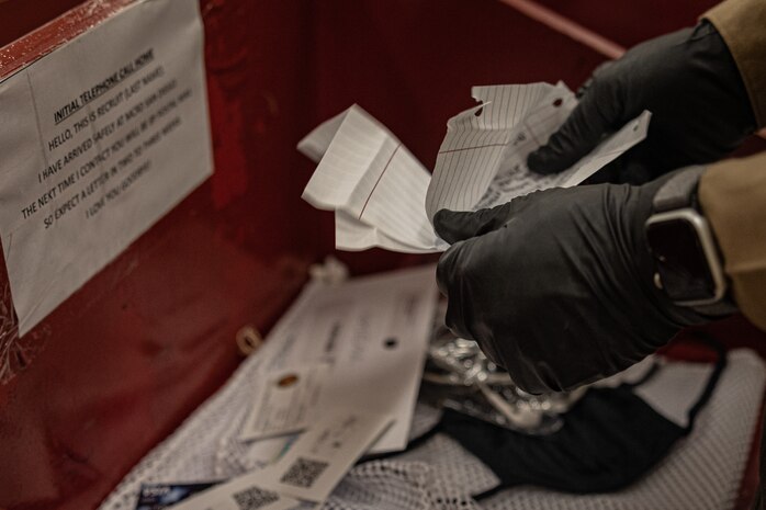 A U.S. Marine Corps drill instructor with Receiving Company, Support Training Battalion, search the belongings of the new recruits for contraband as part of a receiving event for Echo Company, 2nd Recruit Training Battalion, at Marine Corps Recruit Depot San Diego, California, Nov. 4, 2024. During the receiving process, recruits are checked for contraband, given a haircut, make a scripted phone calls home, and issued their gear required for training. (U.S. Marine Corps photo by Lance Cpl. Jacob B. Hutchinson)