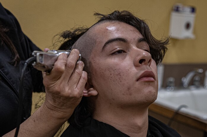 A new U.S. Marine Corps recruit with Echo Company, 2nd Recruit Training Battalion, is given a haircut as part of a receiving event at Marine Corps Recruit Depot San Diego, California, Nov. 4, 2024. During the receiving process, recruits are checked for contraband, given a haircut, make a scripted phone calls home, and issued their gear required for training. (U.S. Marine Corps photo by Lance Cpl. Jacob B. Hutchinson)