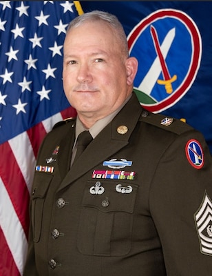 Official photo of Command Sgt. Major Vern B. Daley in front of the U.S. Flag and the Military District of Washington flag.