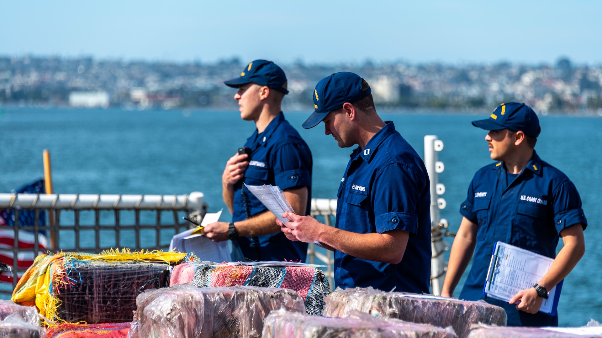 Crewmembers of the U.S. Coast Guard Cutter Munro (WMSL 755) work on the flight deck of the cutter during the contraband offload in San Diego, Nov. 19, 2024.   The Munro's crew interdicted the narcotics in the Eastern Pacific during counter-narcotic patrols, seizing more than 29,000 pounds of cocaine worth an estimated wholesale value of $335.8 million.  (U.S. Coast Guard photo by Petty Officer 3rd Class Richard Uranga)