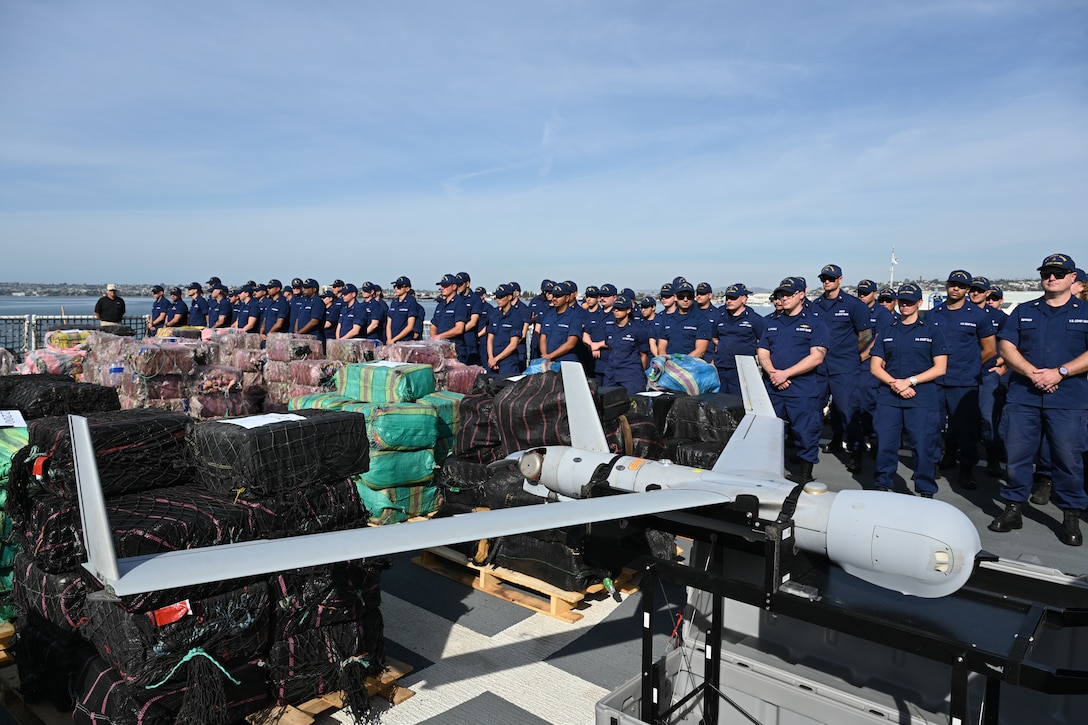 A U.S. Coast Guard Cutter Munro (WMSL 755) crewmembers stand alongside rows of seized contraband aboard the cutter prior to offloading the contraband while moored in San Diego, Nov. 19, 2024. The offload is a result of eleven separate suspected drug smuggling vessel interdictions or events off the coasts of Mexico and Central and South America by the Coast Guard Cutters Munro, Vigorous, Hamilton, and the USS St. Louis in September and October. U.S. Coast Guard photo by Petty Officer 3rd Class Austin Wiley.