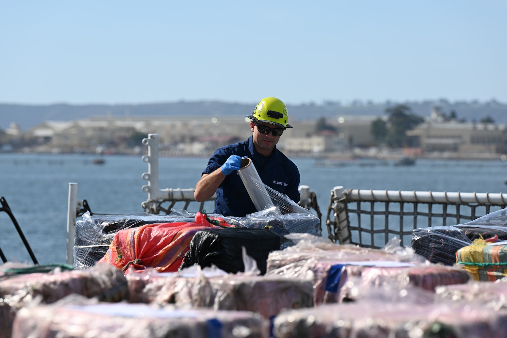 A U.S. Coast Guard Cutter Munro (WMSL 755) crewmember prepares contraband to be offloaded from the Munro while moored in San Diego, Nov. 19, 2024. The offload is a result of eleven separate suspected drug smuggling vessel interdictions or events off the coasts of Mexico and Central and South America by the Coast Guard Cutters Munro, Vigorous, Hamilton, and the USS St. Louis in September and October. U.S. Coast Guard photo by Petty Officer 3rd Class Austin Wiley.