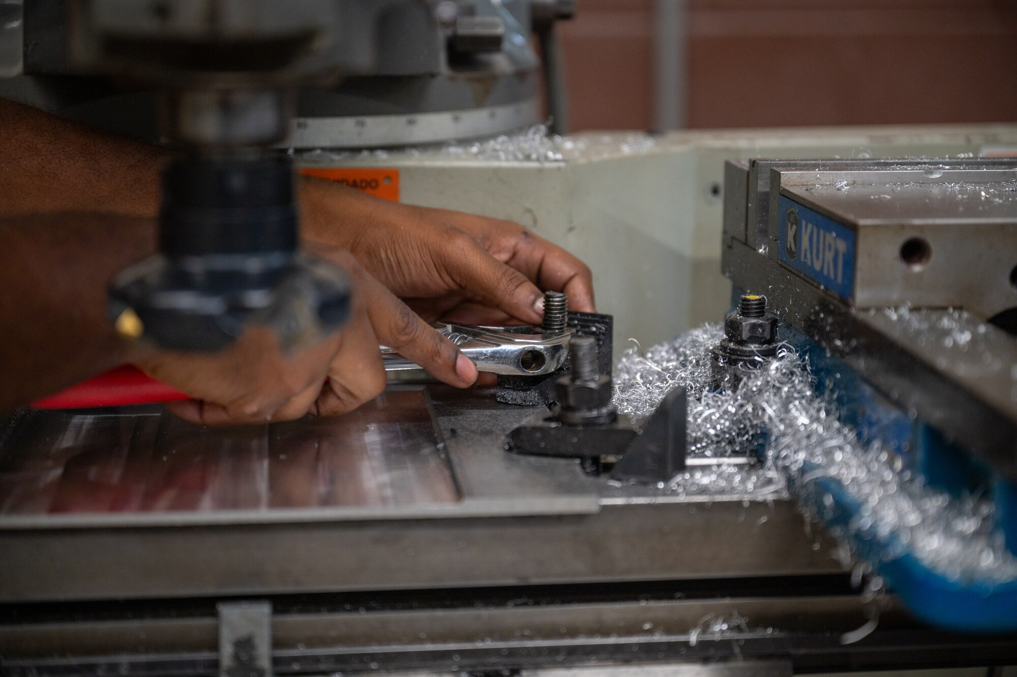 A person uses a tool while working in the maintenance career field.