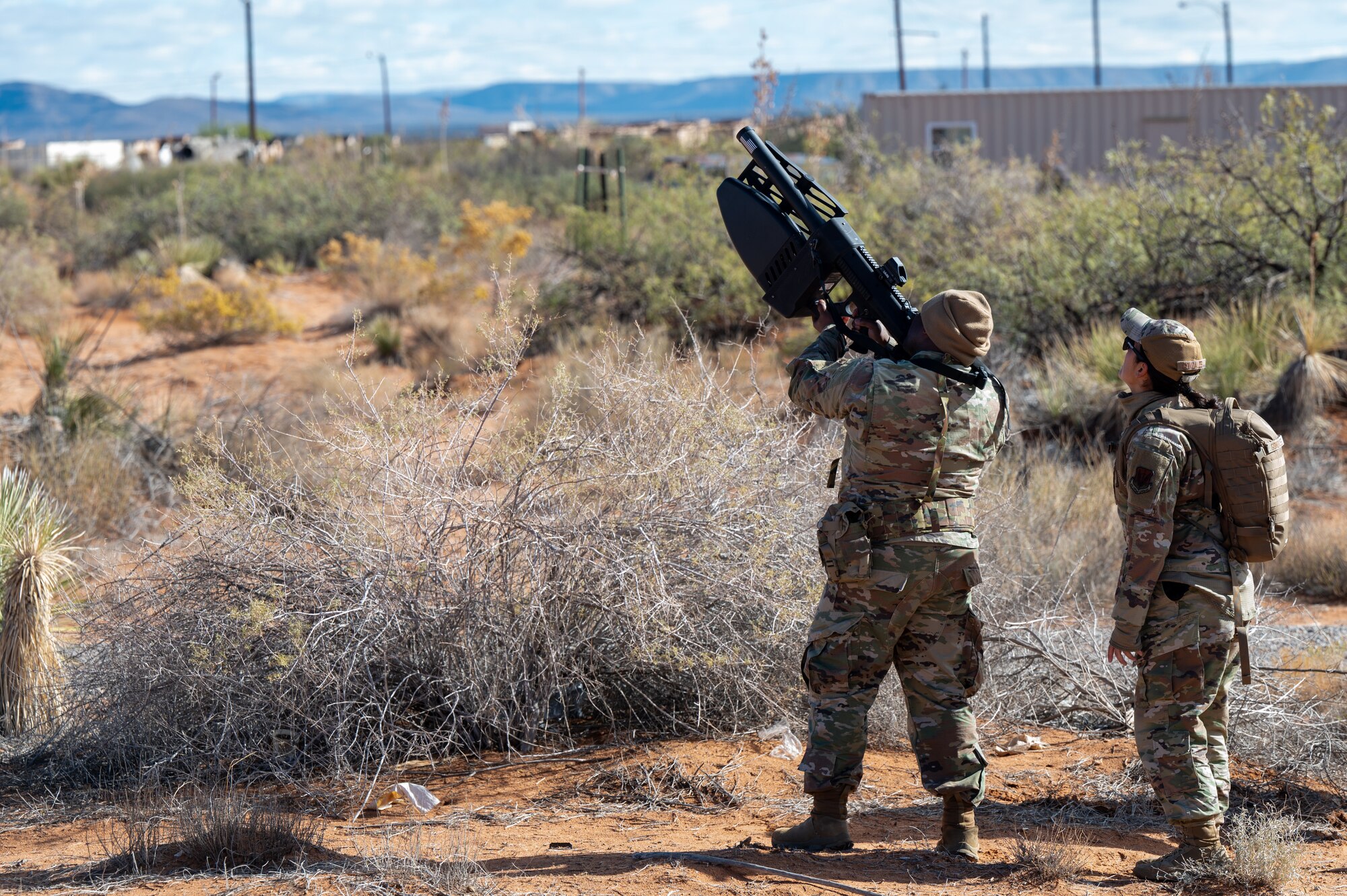 U.S. Air Force Lt. Col. Nathaniel Steward, 11th Air Task Force chief of staff, uses a counter-unmanned aerial system while Senior Airman Thalia Gonzales, 355th Communications Squadron radio frequency transmission systems technician, visually tracks the UAS at McGregor Range, New Mexico, Nov. 8, 2024. Airmen gained experience detecting, tracking and disrupting drones. (U.S. Air Force photo by Airman 1st Class Jasmyne Bridgers-Matos)