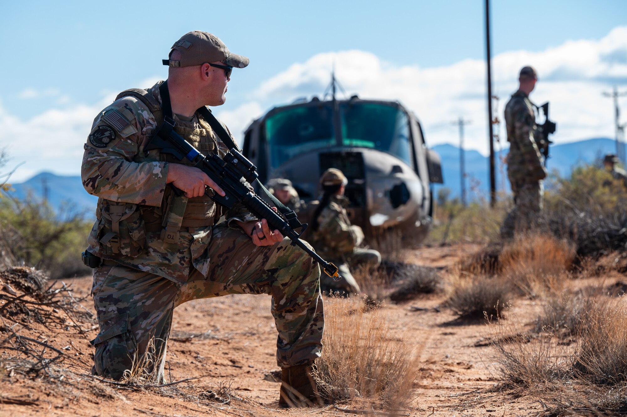 A U.S. Airman assigned to the 11th Air Task Force guards his team while they recover assets from a simulated downed helicopter at McGregor Range, New Mexico, Nov. 8, 2024. Airmen demonstrated their proficiency in using tactical movement and strategies to complete the mission. (U.S. Air Force photo by Airman 1st Class Jasmyne Bridgers-Matos)