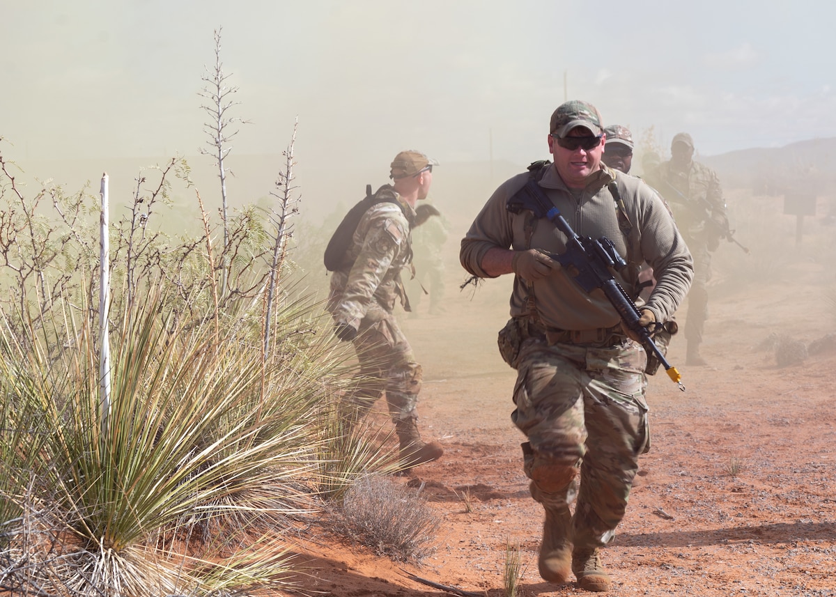 U.S. Airmen assigned to the 11th Air Task Force seek cover during a simulated attack at McGregor Range, New Mexico, Nov. 8, 2024. Airmen created and executed a simulated plan to recover assets and regroup with allied forces in a contested environment. (U.S. Air Force photo by Airman 1st Class Jasmyne Bridgers-Matos)