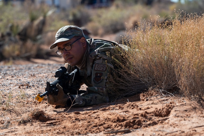 U.S. Air Force Staff Sgt. Rene Urbina Rumayor, 49th Force Support Squadron food service supervisor, takes cover during the first 11th Air Task Force field exercise at McGregor Range, New Mexico, Nov. 8, 2024. Airmen encountered simulated threats and determined the best course of action to carry out the mission. (U.S. Air Force photo by Airman 1st Class Jasmyne Bridgers-Matos)