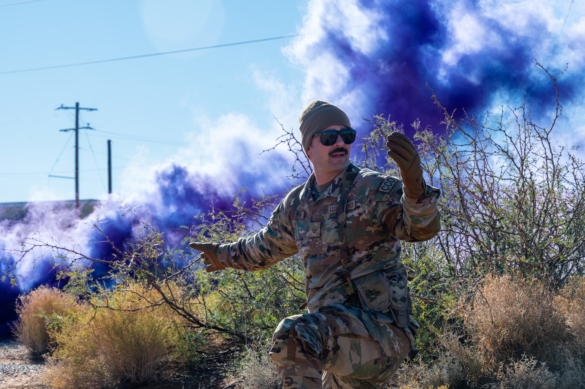 A U.S. Airman assigned to the 11th Air Task Force signals for his team to move forward during the first 11th ATF field exercise at McGregor Range, New Mexico, Nov. 8, 2024. Airmen used visual signals to communicate with their team while in a simulated contested environment. (U.S. Air Force photo by Airman 1st Class Jasmyne Bridgers-Matos)