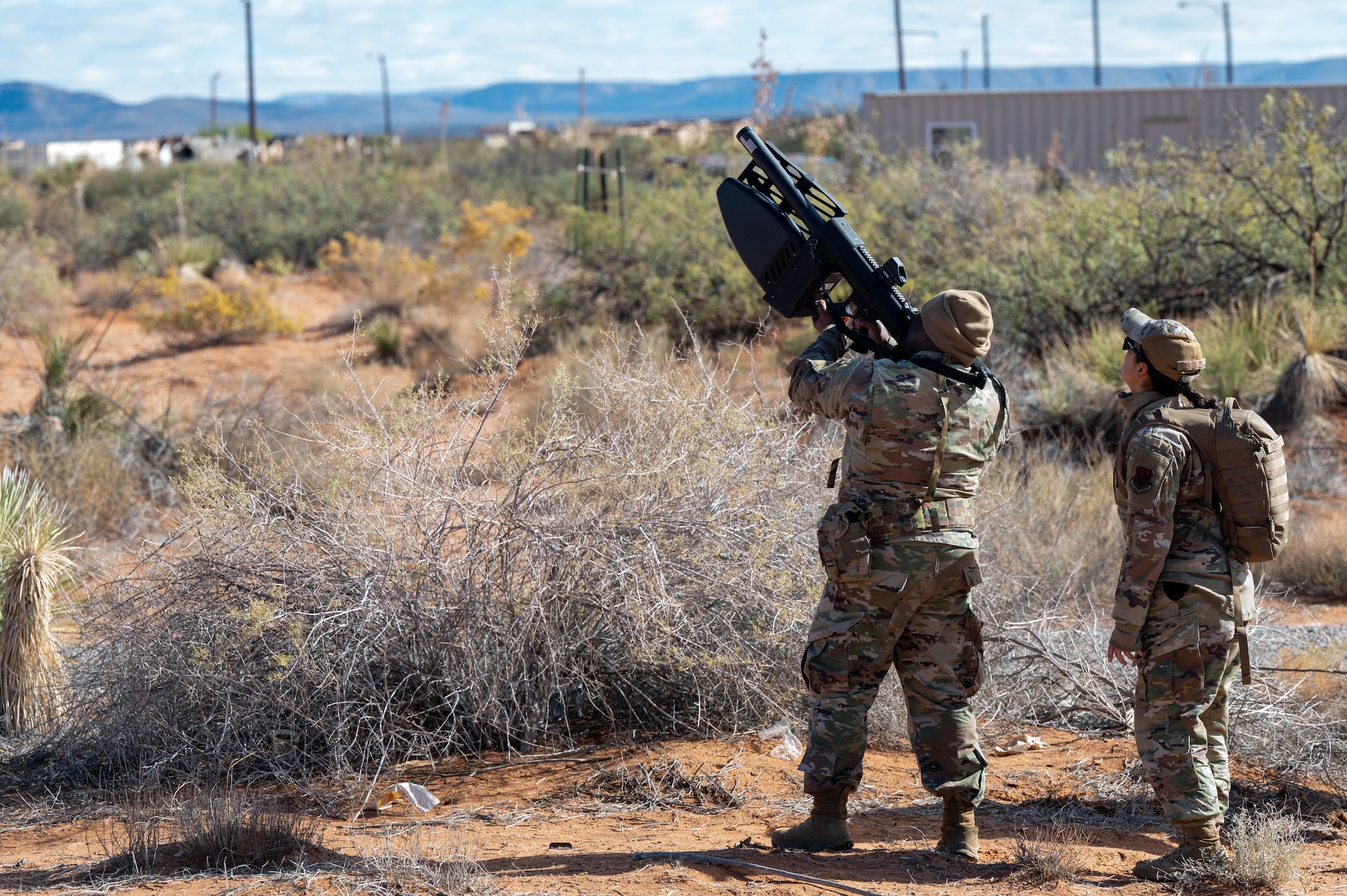 U.S. Air Force Lt. Col. Nathaniel Steward, 11th Air Task Force chief of staff, uses a counter-unmanned aerial system while Senior Airman Thalia Gonzales, 355th Communications Squadron radio frequency transmission systems technician, visually tracks the UAS at McGregor Range, New Mexico, Nov. 8, 2024. Airmen gained experience detecting, tracking and disrupting drones. (U.S. Air Force photo by Airman 1st Class Jasmyne Bridgers-Matos)