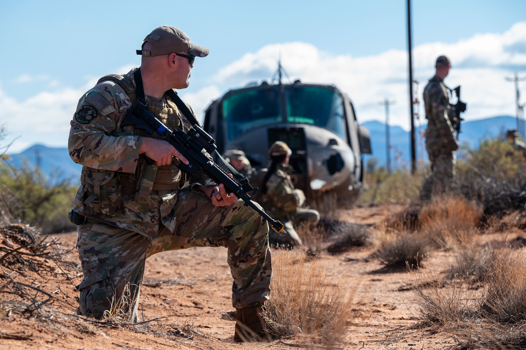 A U.S. Airman assigned to the 11th Air Task Force guards his team while they recover assets from a simulated downed helicopter at McGregor Range, New Mexico, Nov. 8, 2024. Airmen demonstrated their proficiency in using tactical movement and strategies to complete the mission. (U.S. Air Force photo by Airman 1st Class Jasmyne Bridgers-Matos)