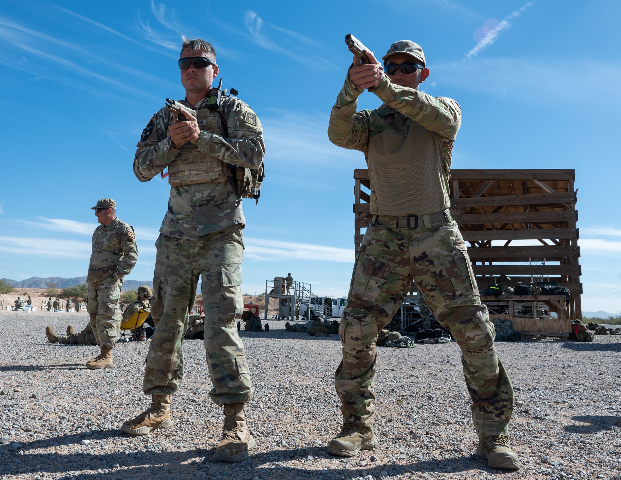 U.S. Army Staff Sgt. Richard Middaugh, 2-363rd Training Support Battalion range safety officer, right, demonstrates proper stance when drawing an M18 pistol to Air Force Master Sgt. Jan Lozano, 11th Combat Air Base Squadron infrastructure superintendent, at McGregor Range, New Mexico, Nov. 12, 2024. Middaugh conducted M18 pistol familiarization training as part of the 11th Air Task Force’s first field training exercise. (U.S. Air Force photo by Airman 1st Class Jasmyne Bridgers-Matos)